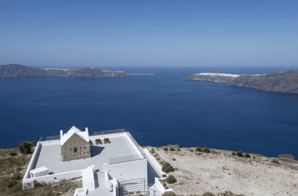 The image is the rooftop of the house and the surrounding field along with the caldera view showing the privacy it has. Indicating that when staying here we will be your travel guide.